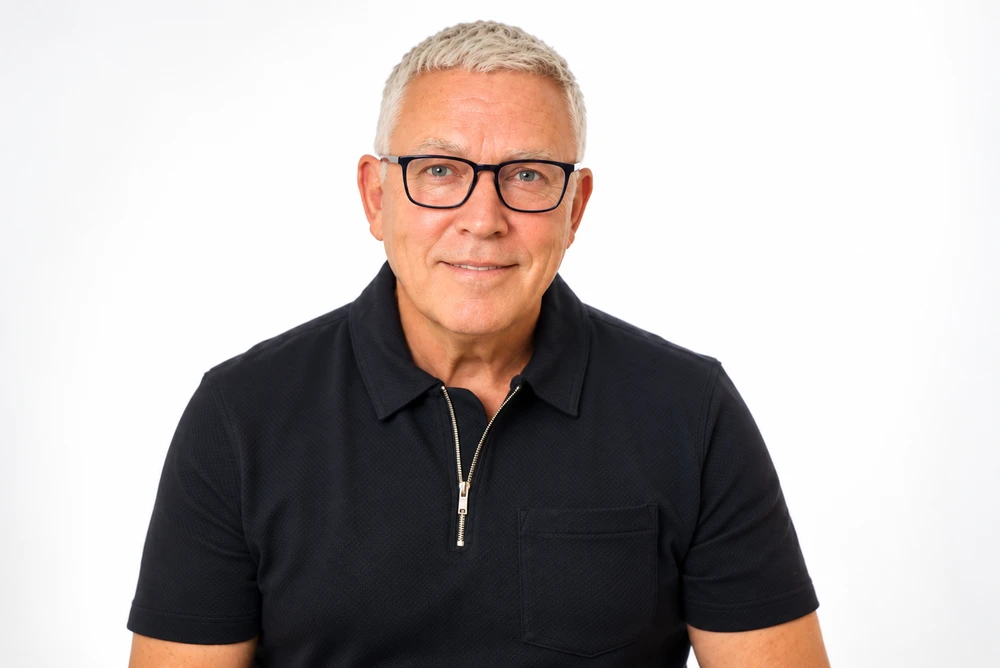 Kerry Ball, wearing glasses and a black polo shirt.
